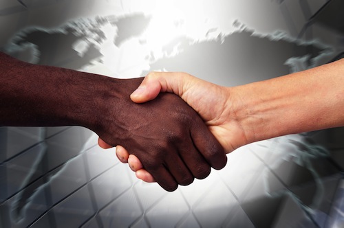 Handshake with black hand and white hand - shutterstock